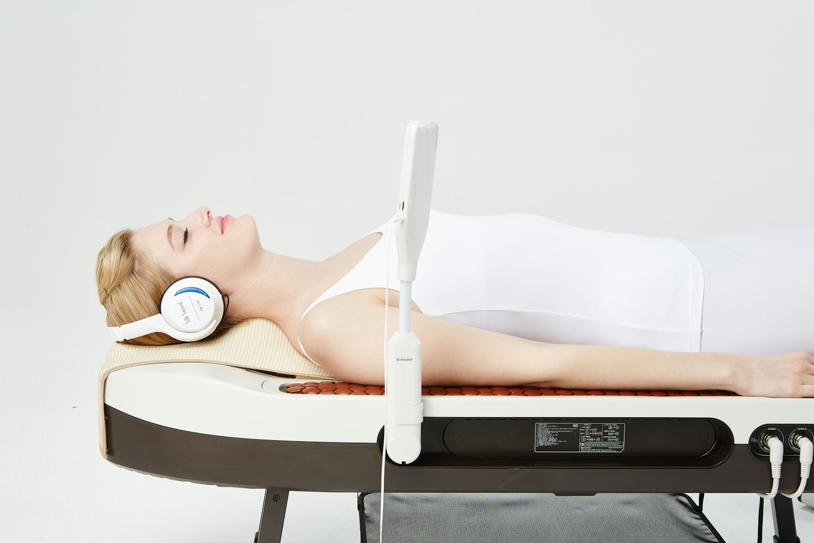 a woman laying on a bed with headphones on